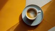  a cup of coffee sitting on top of a saucer on top of a yellow and white striped table cloth.