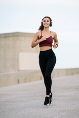 Active sport fitness woman jogging outside. Female young adult athlete running training cardio for marathon.