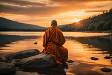 A Photo Of A Monk In Orange Robes Sitting On A Rock In A Lake At Sunset, With The Sky And The Water Reflecting The Warm Colors.