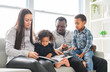 © Louis-Paul Photo - family with boy and girl child posing on photo shooting, sitting on couch and reading book