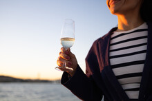 Unrecognizable Young Woman With Glass Of Drink Standing Against Sea