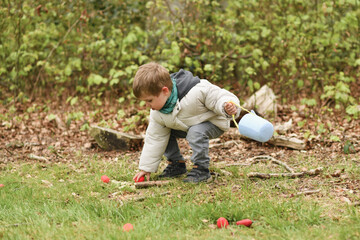 A boy looking for eggs in a bag for Easter