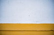 pared lisa de dos colores amarillo y blanco con algunas pequeñas grietas e imperfectos 