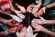 © Andrew Kornylak - The chalk-covered and weathered hands of a group of rock climbers palm up and facing eachother in a circle