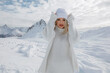 Beautiful blonde girl in the mountains of the Swiss Alps. Winter sunny day, a lot of snow. Resort