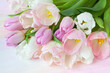 Bouquet of pink, white and purple tulips closeup on colorful watercolor paper background, beautiful postcard.