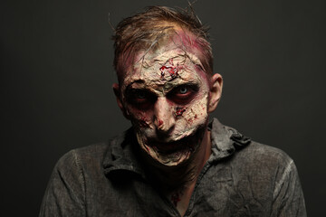 Wall Mural - Scary zombie on dark background. Halloween monster