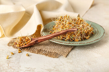 Wall Mural - Spoon and plate with sprouted wheat on grunge table