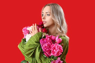 Wall Mural - Young woman with beautiful peony flowers on red background