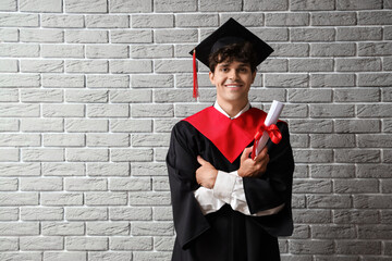 Poster - Male graduate student with diploma on grey brick background