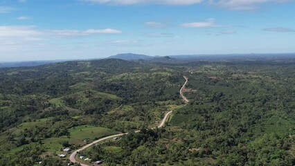 Wall Mural - Road on green hills above drone view in beautiful landscape