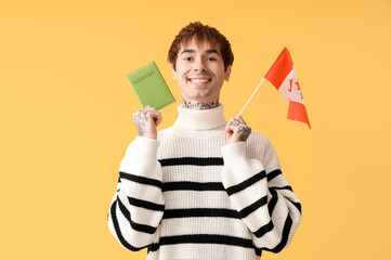 Canvas Print - Handsome young man with flag of Canada and passport on yellow background. Immigration concept