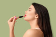 © Pixel-Shot - Beautiful young woman with stylish lipstick on green background