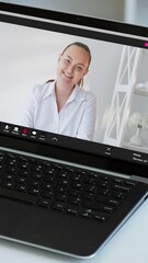 Wall Mural - Vertical video. Internet meeting. Professional telecommuting. Distance work. Successful business woman on laptop screen speaking at home office.