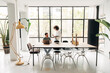 © Daniel - Young multiracial people interacting in spacious bright co working office with big window,