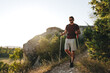 © fotofabrika - Young man hiker travels through the mountains with trekking poles for nordic walking