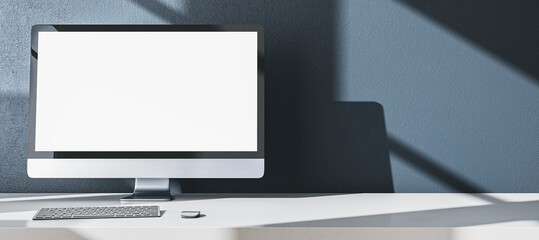 Poster - Modern designer office desktop with empty white mock up computer monitor, supplies and other items on wide gray wall background. 3D Rendering.