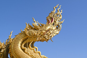 Wall Mural - Traditional thai dragon statue against blue sky at a temple in Thailand