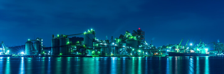 Giant cement plants illuminated at night.