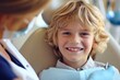 A smiling young blond boy in a dental chair. Examination by a dentist