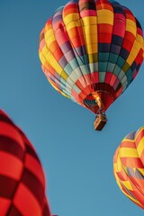 Poster - Colorful hot air balloons flying gracefully through a clear blue sky. Perfect for travel or adventure concepts
