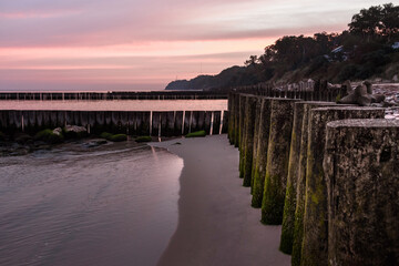 Wall Mural - Wooden groynes on the beach of Baltic sea in Svetlogorsk at sunrise. Kaliningrad region. Russia