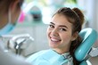 © fledermausstudio - A smiling young woman with open mouth in a dental chair