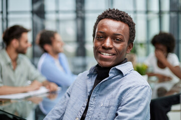 smiling African American business man with executives working in background