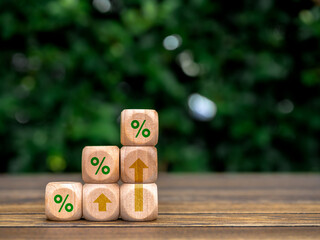 Poster - Green percentage and rise up arrows on wooden cube blocks as a business graph steps on table and green leaves background with copy space. Business growth, investment growing and success concepts.