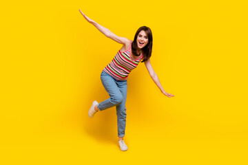 Sticker - Full body photo of positive good mood girl wear striped tank denim trousers hold arms like wings isolated on yellow color background