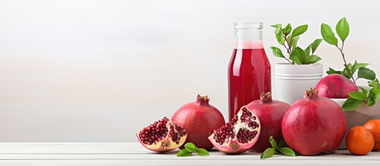 Wall Mural - Vertical picture of pomegranates and pomegranate drinks on a white desk with a bright wall.