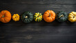 A group of pumpkins on a dark gray color wood boards