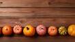 A group of pumpkins on a light maroon color wood boards