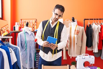 Canvas Print - Young hispanic man tailor using touchpad at atelier