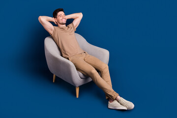 Sticker - Full length photo of relaxed satisfied man wear beige outfit lay on armchair hold arms behind head isolated on dark blue color background