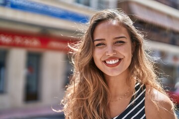 Wall Mural - Young beautiful hispanic woman smiling confident standing at street