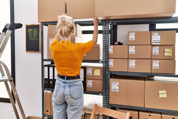 Poster - Young blonde woman ecommerce business worker organizing packages on shelving at office