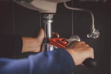 plumber at work in a bathroom, plumbing repair service , fix water plumbing leaks, replace the kitchen sink drain