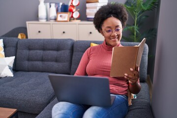 Poster - African american woman using laptop reading book at home