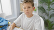 © Krakenimages.com - Adorable blond boy student concentrating and taking notes at his desk in classroom setting