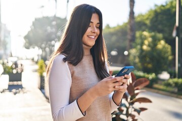 Poster - Young beautiful hispanic woman smiling confident using smartphone at street