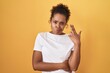 © Krakenimages.com - Young hispanic woman with curly hair standing over yellow background shooting and killing oneself pointing hand and fingers to head like gun, suicide gesture.