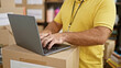 © Krakenimages.com - Handsome middle-aged caucasian man volunteering at charity center, confidently using laptop amidst service. portrait of a bearded adult male, embodying unity and altruism indoors.