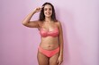 Young hispanic woman wearing lingerie over pink background smiling pointing to head with one finger, great idea or thought, good memory