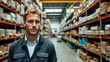 Portrait of a man standing in a big warehouse with shelves full of boxes.