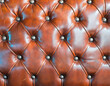 Luxury leather upholstery with buttons closeup background.