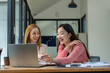 © Wasana - Two business colleagues talking share ideas while meeting remotely with team on laptop.