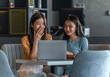 © StockPhotoRepublic - Weekend Out-of-Office Collaboration. Two young Asian woman break away from the office, opting for a cozy café to discuss work.