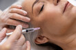 Beautician doing filler injections to a mature female patient