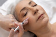 Woman having anti wrinkle filler injections to eye area
